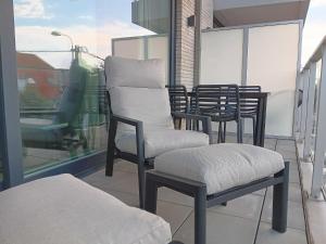 a balcony with chairs and a table and a window at Zilt 0202 in Westende