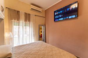 a bedroom with a bed and a television on the wall at Casa Medicea sul canale in Livorno