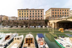 a group of boats docked in a canal with buildings at Casa Medicea sul canale in Livorno