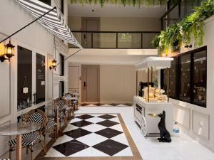 a kitchen with a black cat sitting on a checkered floor at The Iconic in Pattaya