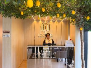 a woman sitting at a table in a room with oranges at The Iconic in Pattaya