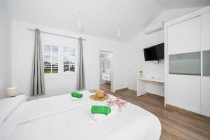 a white bedroom with a large white bed and a window at Villa Yaiza Secret 2 in Yaiza +12 photos