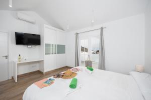 a white bedroom with a bed and a tv at Villa Yaiza Secret 2 in Yaiza