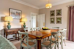 a dining room with a wooden table and chairs at West House in High Legh