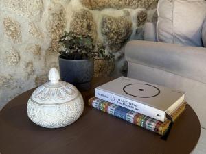 a table with books and a vase on a table at Serena Nest 01 in Rio Douro