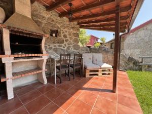 an outdoor patio with a pizza oven and chairs at Serena Nest 01 in Rio Douro +7 photos