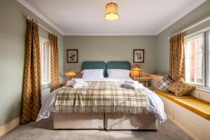 a bedroom with a bed and two windows at West House in High Legh