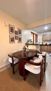 a dining room with a wooden table and chairs at Midtown LakeView 2BR House with Heated pool, Netflix, 24Hr security & reception -Shawmut Nakuru in Nakuru