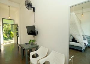 a living room with a table and chairs and a bed at Kithal Ella Station Resort in Ella