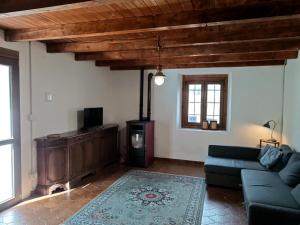 a living room with a blue couch and a tv at La Caserma -The Barracks in Bobbio Pellice