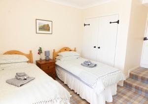 two beds in a room with white walls at Craiglea Barn in Latheron