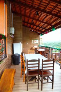 a dining room with a table and chairs on a deck at Village vila verde in Itaitu