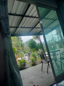 a screened in porch with a chair on a patio at บ้านสวนริมทาง in Ban Pha Saeng Lang