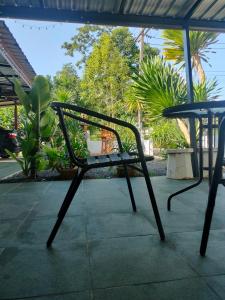 a chair sitting on a patio with a table at บ้านสวนริมทาง in Ban Pha Saeng Lang