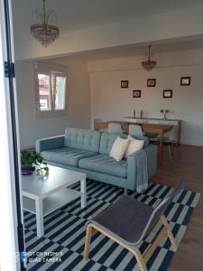 a living room with a blue couch and a table at A Muradana, Aldán in Pontevedra +14 photos