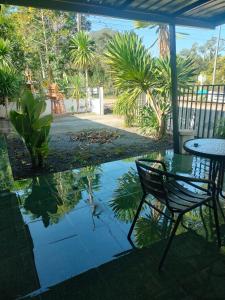 a patio with a table and chair and a pond at บ้านสวนริมทาง in Ban Pha Saeng Lang