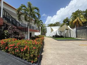 a walkway next to a building with flowers and a tent at Hotel Mar de Corales By CAJASAI in San Andrés
