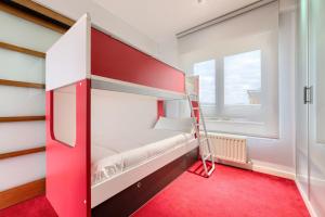 a bunk bed in a room with a red carpet at Apartamento Bilbao Aeropuerto - Derio in Derio