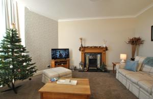a living room with a christmas tree and a couch at Kirkmay House Apartment in Crail
