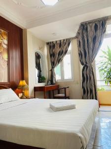 a bedroom with a large white bed and a window at Heaven Hostel in Ho Chi Minh City