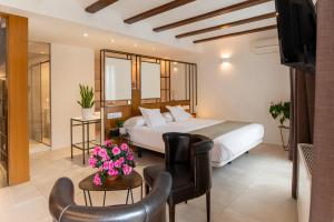 a hotel room with a bed and some chairs at Vinatea Suites con jacuzzi privado en el centro de Morella in Morella