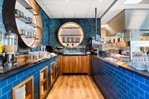 eine große Küche mit blauen Fliesen und einer Theke in der Unterkunft Waterstate Wellness hotel Goes in Goes
