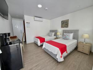 a hotel room with two beds and a flat screen tv at Hotel Mar de Corales By CAJASAI in San Andrés