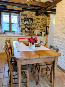 a kitchen with a wooden table with flowers on it at Gîte le pré des Colombes in Troche +9 photos