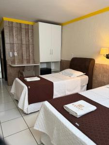 a hotel room with two beds and a kitchen at Hotel Estilo in Arapiraca