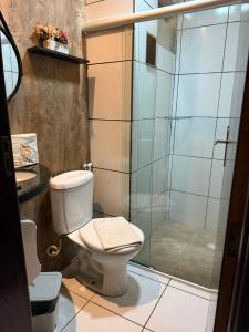a bathroom with a toilet and a shower at Hotel Estilo in Arapiraca