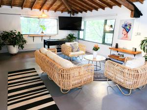 a living room with wicker furniture and a piano at Vintage House With Jacuzzi In Manila in Medellín