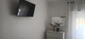 a living room with a tv on the wall at Casa da Gena in Nazaré +15 photos
