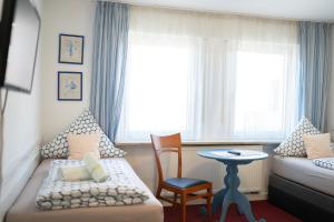 a room with a bed and a chair and a table at Hotel Eintracht in Fellbach