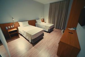 a hotel room with two beds and a television at Clatt Hotel in São João da Boa Vista +58 photos