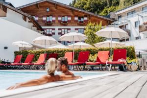 zwei Personen im Swimmingpool eines Hotels in der Unterkunft Familotel Amiamo in Zell am See