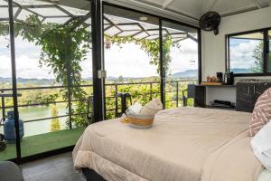 a bedroom with a bed and a view of a river at Rocks Glamping - Guatapé, El Peñol in El Peñol