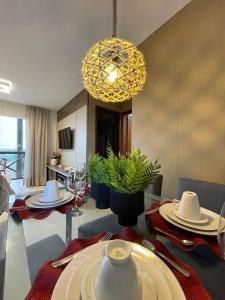 a dining room with a table and a chandelier at Apartamento aconchego na Serra in Bananeiras