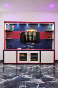 a living room with a tv on a wall at Elite Castle Stay in Kottakupam