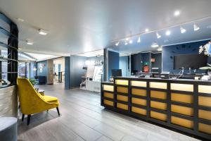 a lobby with a yellow chair and a counter at Scandic Vadsø in Vadsø