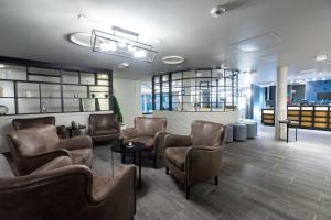 a waiting room with leather chairs and tables and a waiting room at Scandic Vadsø in Vadsø