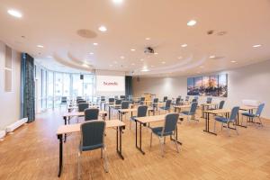 a conference room with tables and chairs and a screen at Scandic Vadsø in Vadsø