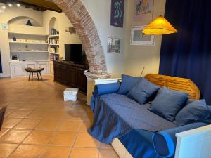a living room with a blue couch in a room at Casa Patrizia nel castello in Rosignano Marittimo