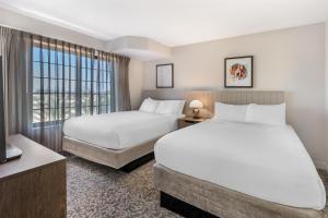 a hotel room with two beds and a window at Sonesta ES Suites Anaheim Resort Area in Anaheim