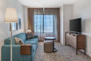 a living room with a couch and a flat screen tv at Sonesta ES Suites Anaheim Resort Area in Anaheim +36 photos