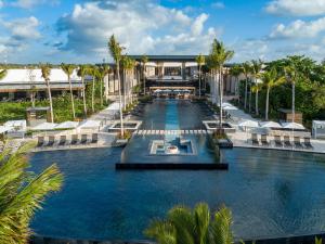 an aerial view of a resort pool with palm trees at Conrad Tulum Riviera Maya in Tulum