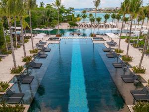 an aerial view of a resort pool with chairs and palm trees at Conrad Tulum Riviera Maya in Tulum