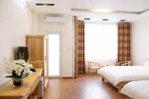 a bedroom with a bed and a table with flowers on it at Vân Nam Hotel in Cao Bằng