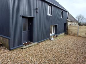 a black building with a door on a gravel yard at The Loft in Kilkenny