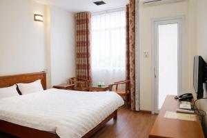 a bedroom with a bed and a desk and a television at Vân Nam Hotel in Cao Bằng