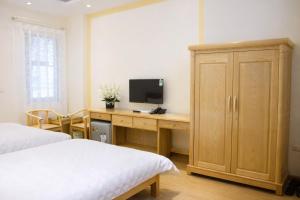 a bedroom with a desk with a television on it at Vân Nam Hotel in Cao Bằng